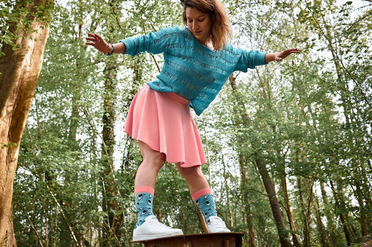 Une jeune femme élégante porte des chaussettes Quanailles assorties à sa tenue, illustrant l'intégration de ces accessoires tendance dans un style personnel.