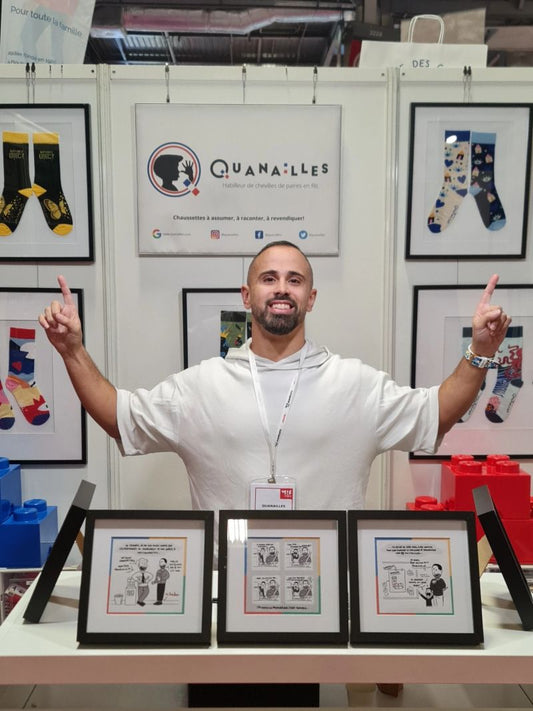 Damien Pedreira posant fièrement devant son stand de chaussettes made in france Quanailles